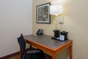 a desk in a hotel room with a phone on it at La Quinta East Deerfield Beach - Boca Raton in Deerfield Beach