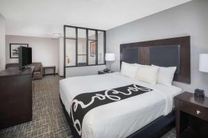 アトランタにあるラ キンタ イン ＆ スイーツ アトランタ エアポート サウスの大型ベッドとテレビが備わるホテルルームです。