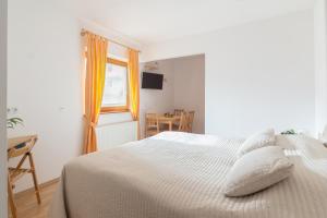 a white bedroom with a bed and a window at Apartments Valant in Bled
