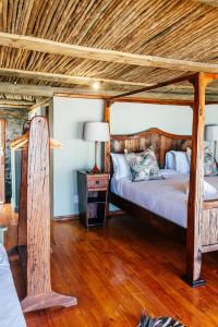 ein Schlafzimmer mit einem Himmelbett und einem Holzboden in der Unterkunft Buccara Lindsay Castle in Knysna