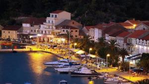 a town with boats in a harbor at night at Apartments Jelavic in Trpanj