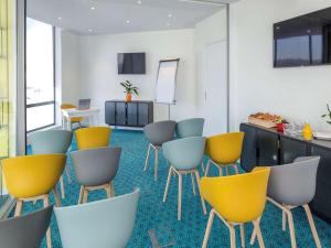 a waiting room with yellow and blue chairs at ibis Lyon Sud Vienne Saint-Louis in Vienne