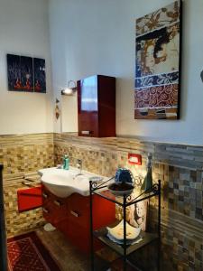 uma casa de banho com um lavatório, um espelho e um balcão em Apartment i viaggi di Mario em Cagliari