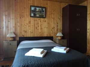 a bedroom with a bed with two towels on it at Котедж на Довбуша in Yaremche