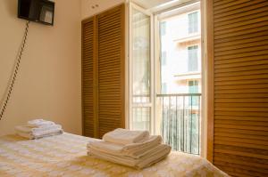 a bedroom with a bed and a window with towels on it at u' recantu' in Sestri Levante