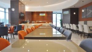 a dining room with tables and chairs and a bar at Holiday Inn Express - Suzhou Industrial Park by IHG in Suzhou
