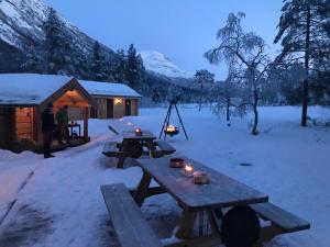 uma mesa de piquenique na neve ao lado de uma cabana em Camp Dronningkrona em Ålvundeid