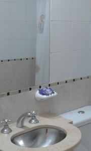 y baño con lavabo, aseo y espejo. en Moreno 186 en Rosario