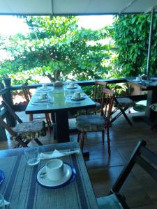 a table and chairs sitting on a porch with a table and chairs at GO Hotelaria in Búzios
