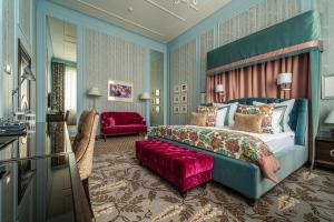 a bedroom with a king sized bed and a red couch at Boutique Hotel Albora in Saint Petersburg