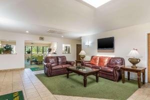 sala de estar con muebles de cuero y TV de pantalla plana en Quality Inn Petersburg Near Fort Gregg-Adams en Southern Estates