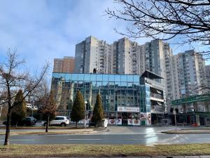 ein großes Glasgebäude in einer Stadt mit hohen Gebäuden in der Unterkunft Hotel Brkić Sarajevo Airport - Free Parking in Sarajevo