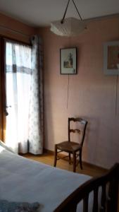 a bedroom with a bed and a chair and a window at Chambre d'hôtes - La Maurillonnette in Saint-Pancrace