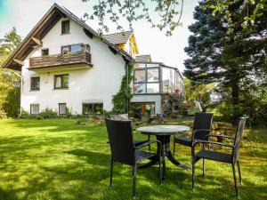 a table and chairs in front of a house at Ferienwohnung Vor der Stephanskuppe in Sinntal
