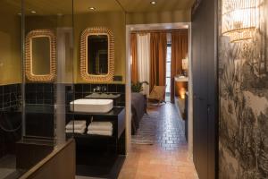 a bathroom with a bed and a sink and mirror at MiHotel Tour Rose in Lyon +212 photos