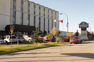 a hotel with cars parked in front of a building at Continental Inn & Suites in Edmonton
