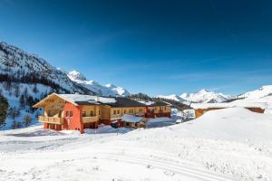 eine Lodge im Schnee mit Bergen im Hintergrund in der Unterkunft Aparthotel Weningeralm in Obertauern