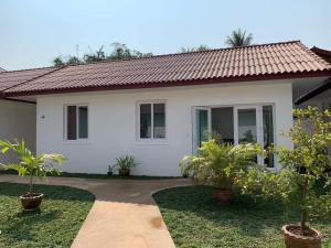 una casa blanca con plantas delante en River View Villas en Vang Vieng