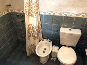 een badkamer met een toilet en een douchegordijn bij Casa Loft Rumipal in Villa Rumipal