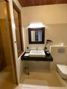 a bathroom with a sink and a toilet at Weligama Bay Resort in Weligama