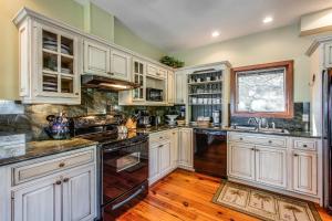 a kitchen with white cabinets and wooden floors at 101 Dune Lane in Hilton Head Island