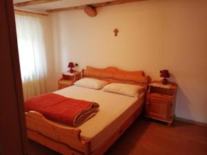 1 dormitorio con 1 cama de madera y 2 mesitas de noche en Giovanna Ribul Moro, en Padola