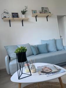 una sala de estar con un sofá y una mesa en Appartement vue mer poste bleu, en Malo-les-Bains
