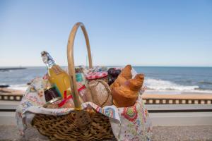 a basket filled with bread and other items next to the beach at Liiiving in Porto - Luxury Beachfront Apartments in Porto