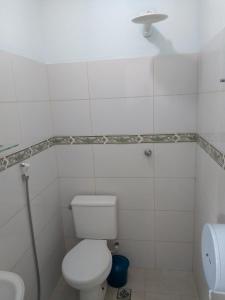 a white bathroom with a toilet and a sink at POUSADA DOS AMIGOS in Presidente Venceslau