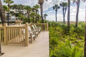 een houten terras met stoelen en palmbomen bij Hampton Place 6407 in Hilton Head Island