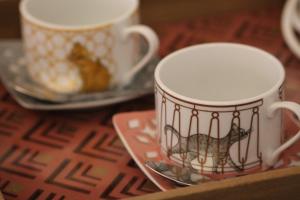 two coffee cups and a plate on a table at Villa Aedan Sintra in Sintra