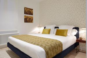 sypialnia z dużym białym łóżkiem i żółtymi poduszkami w obiekcie Mayor Suite 8 by FeelFree Rentals w mieście San Sebastián