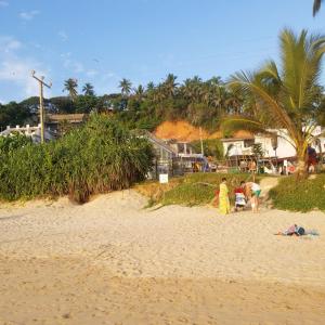 ミリッサにあるChaya Mega Hostelの砂浜に立つ人々