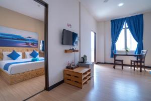 a bedroom with a bed and a mirror and a desk at Paretto Seaview Hotel in Pantai Cenang