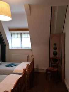 1 dormitorio con 1 cama, 1 silla y 1 ventana en Le Manoir du Gouverneur en Villedieu-le-Château