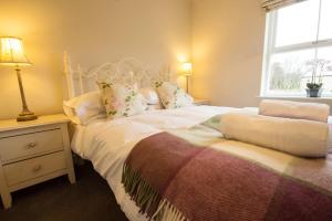 a bedroom with a large bed and a window at Haddon Cottage - Darwin Lake Holiday Village in Matlock