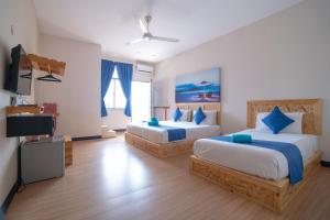 a bedroom with two beds and a flat screen tv at Paretto Seaview Hotel in Pantai Cenang