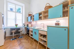 a kitchen with blue cabinets and a sink at Munda house Big design family friendly 4BR apt in Ljubljana