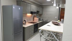 a kitchen with gray cabinets and a refrigerator at Cabanas 21 in Kingsborough