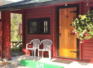 two chairs sitting outside of a red shed at Miette Hot Springs Bungalows in Jasper