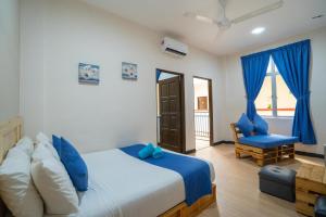 a bedroom with a bed and a chair and a window at Paretto Seaview Hotel in Pantai Cenang
