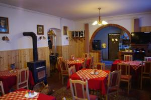 a restaurant with tables and chairs and a stove at Vadszőlő Szálló és Étterem Bakonybél in Bakonybél