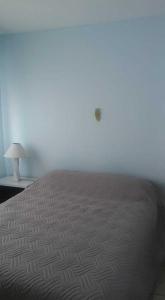 a bedroom with a bed and a lamp on a table at Club del Mar in Punta del Este