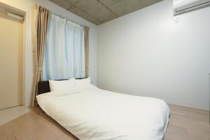 Postel nebo postele na pokoji v ubytování Laffitte Tokyo WEST
