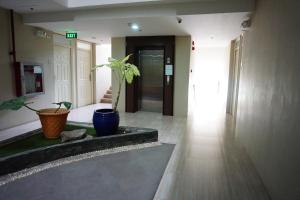a hallway with a potted plant in a building at Cozy condo unit 5mins from Mactan Cebu Int'l Airport with Netflix in Mactan