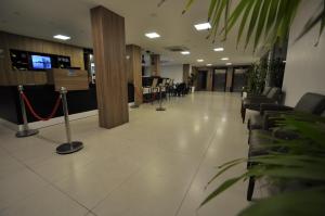 a lobby with chairs and tables in a building at Rede Andrade Barravento in Ilhéus +39 photos