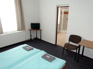 イェセニークにあるHOTEL STAŘÍČのベッド、テーブル、椅子が備わる客室です。