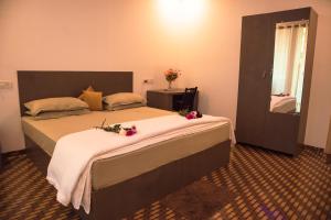 ein Schlafzimmer mit einem großen Bett mit Blumen darauf in der Unterkunft Patnem Beach Cottages in Patnem