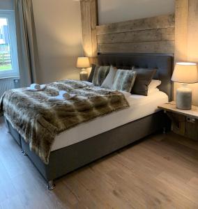 a bedroom with a large bed with a wooden headboard at ferienapartment hahnenklee Apart 1 in Hahnenklee-Bockswiese