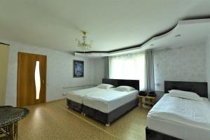 una camera da letto con due letti e una finestra di Jamilya's B&B Guest House a Karakol